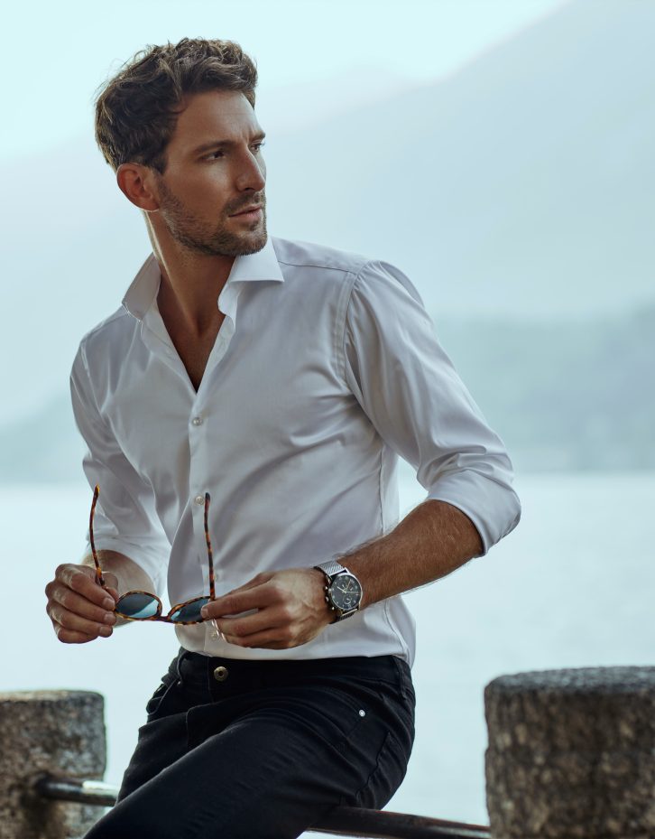 Stylish man in white classic shirt, looking at the mountains view